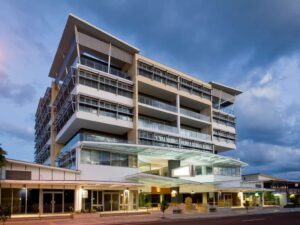 Modern multi-story building housing the Integrated Wellness Clinic, featuring large glass windows and a welcoming entrance, located in Mooloolaba on the Sunshine Coast.