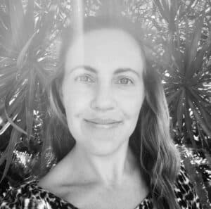 Naturopath Suzi Le Fanue smiling outdoors, surrounded by greenery, promoting holistic health and wellness at Integrated Wellness Clinic.