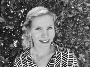 Shani Sulter, Senior Naturopath Mentor at Integrated Wellness Clinic, smiling in front of greenery, representing personalized health care and client relations expertise.