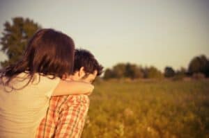 Couple embracing in a sunny field, symbolizing relationship and couples counselling services offered by Integrated Wellness Clinic on the Sunshine Coast and Brisbane.