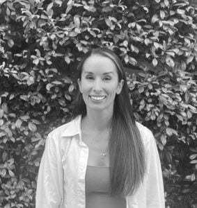 Vanessa Mandich, Integrative Naturopath, standing outdoors with greenery in the background, promoting personalized naturopathic care and gut health expertise.