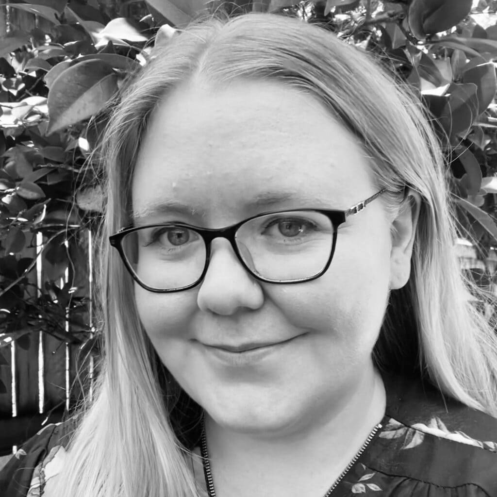 Dr. Kirstie Daken, clinical psychologist, smiling in a warm, welcoming outdoor setting, emphasizing supportive mental health care at Integrated Wellness Clinic.