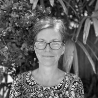 Psychologist Jenny Saulitis standing outdoors among greenery, specializing in autism assessments for children ages 6-14 at Integrated Wellness Clinic in Sunshine Coast.