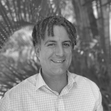 Michael Stone, psychologist at Integrated Wellness Clinic, smiling in a welcoming outdoor setting, promoting mental health support for adults.